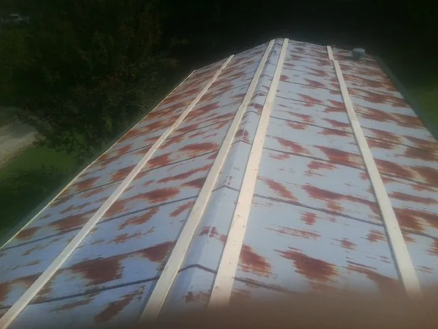 Rusted metal roof panels with new wood purlins before replacement — Storm Damage Roof Repair in Laconia by Roofing Brothers
