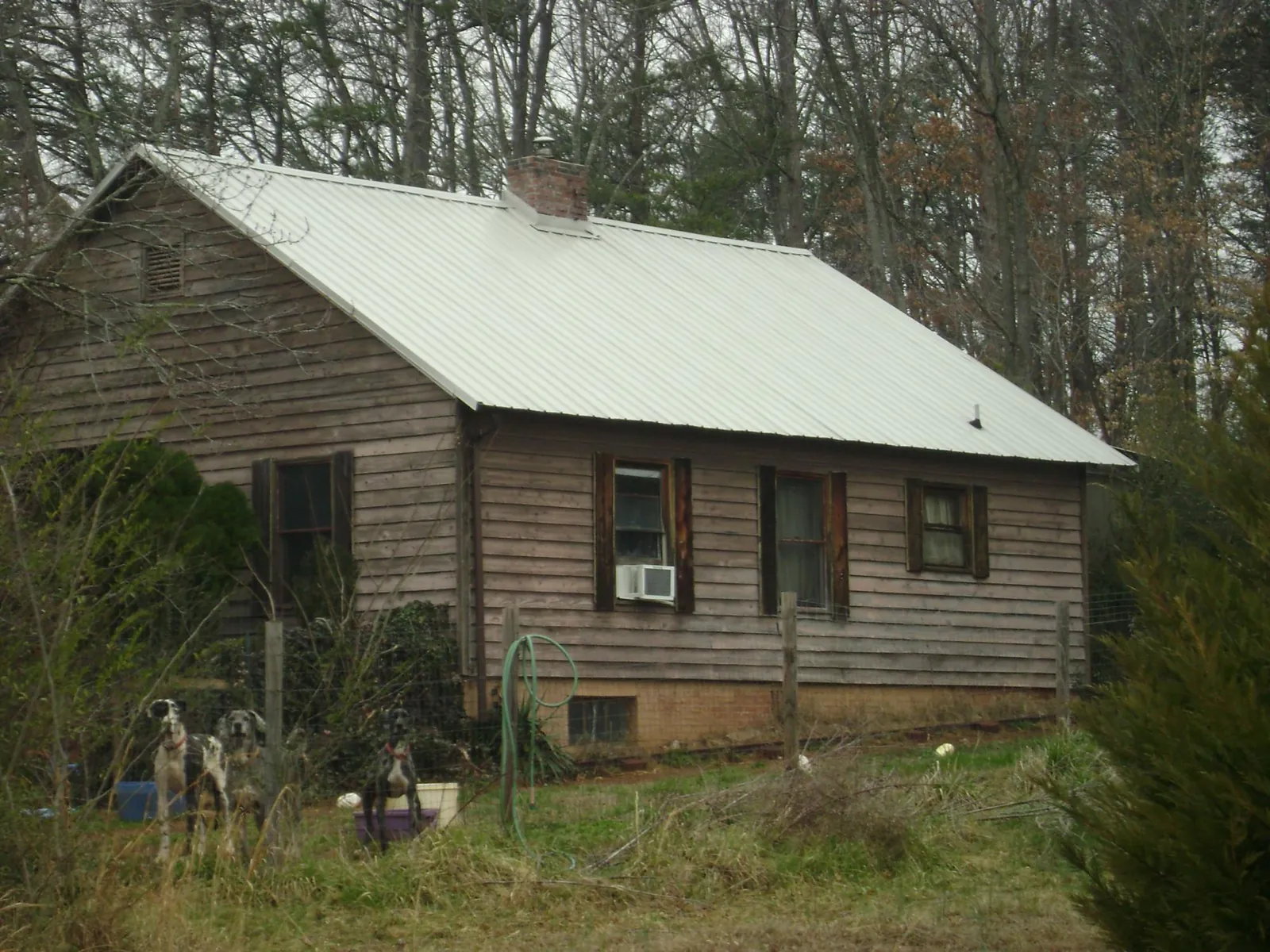 White metal roof on an old wood sided farmhouse, from a Metal Roof Installation job in Laconia